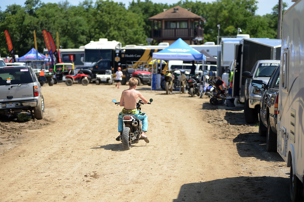 A shirtless racer rides down the main staging area